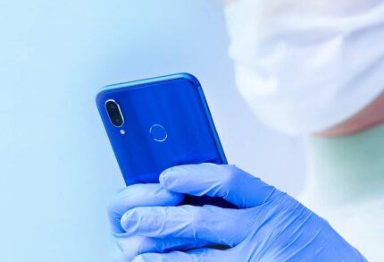 Woman with face mask and gloves looking at her phone