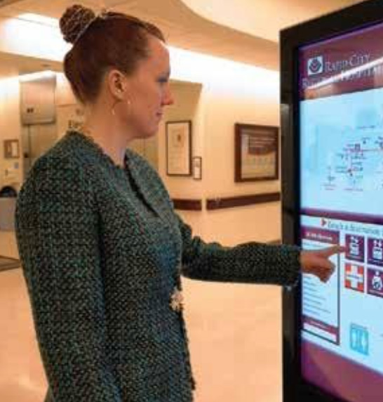 Woman interacting with touchscreen kiosk