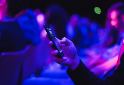 Person holding their phone at a conference